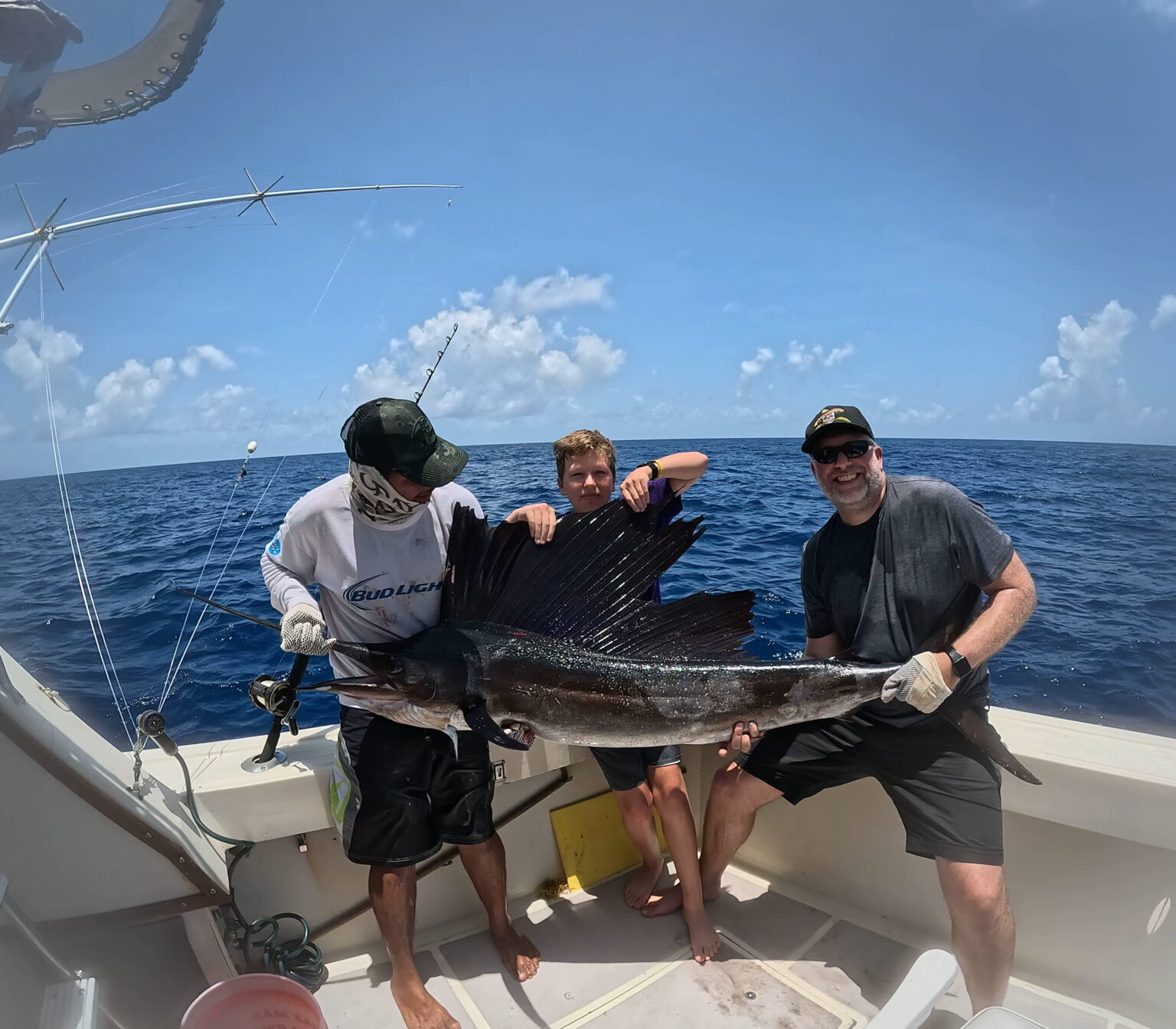 Guests holding a sailfish aboard before releasing it