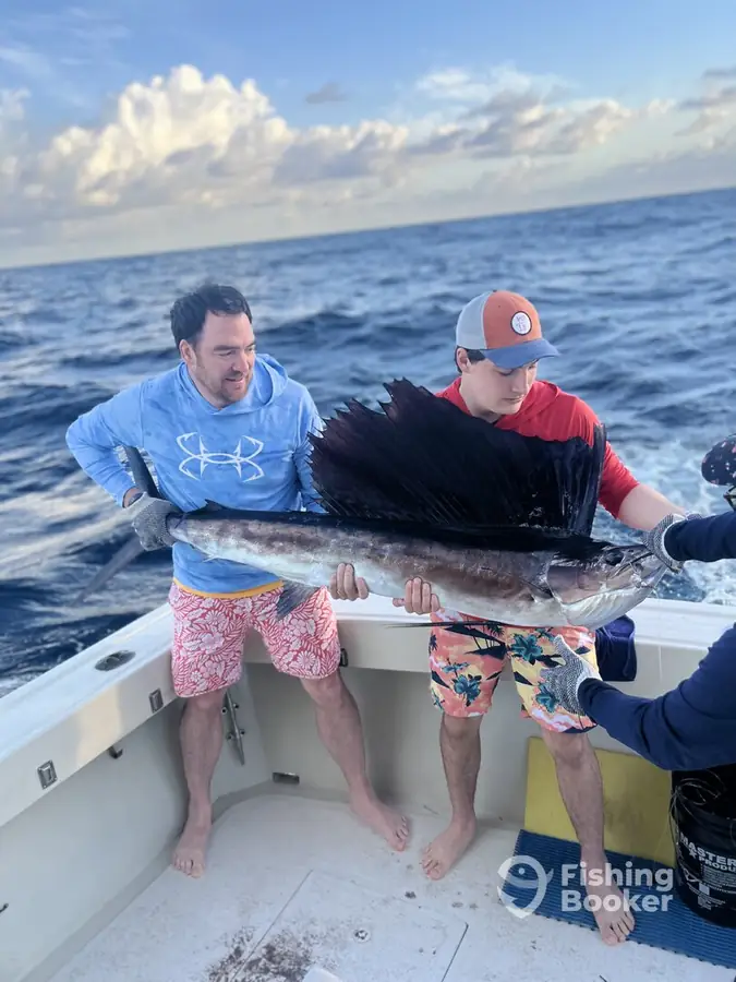 Two guests with a sailfish aboard Cape Escape