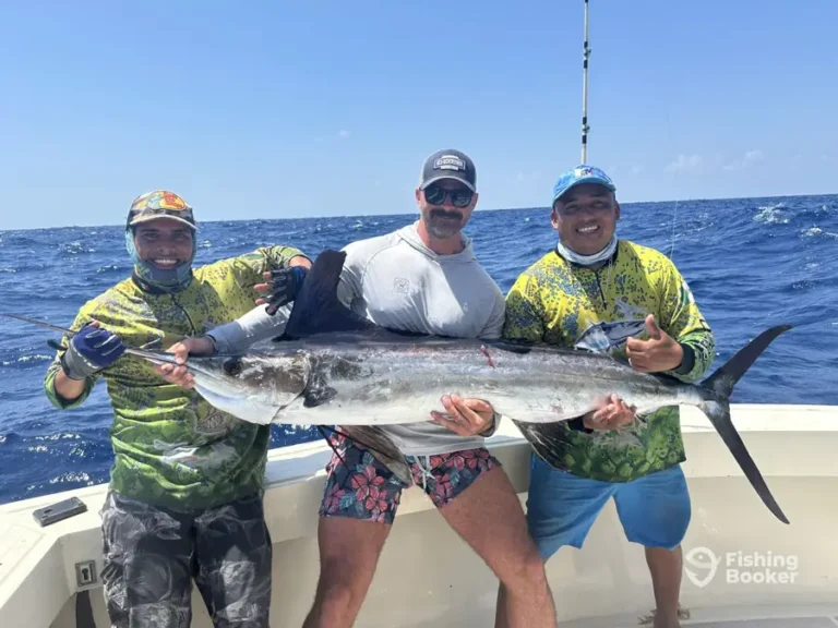 Guests with a sailfish aboard Cape Escape