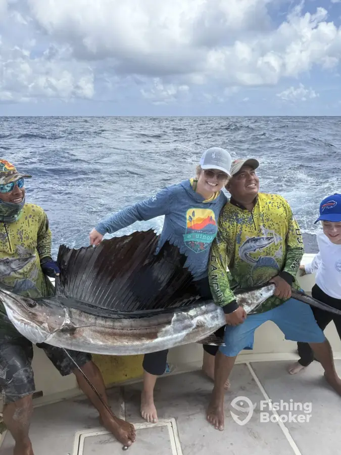 Guests with a sailfish aboard Cape Escape