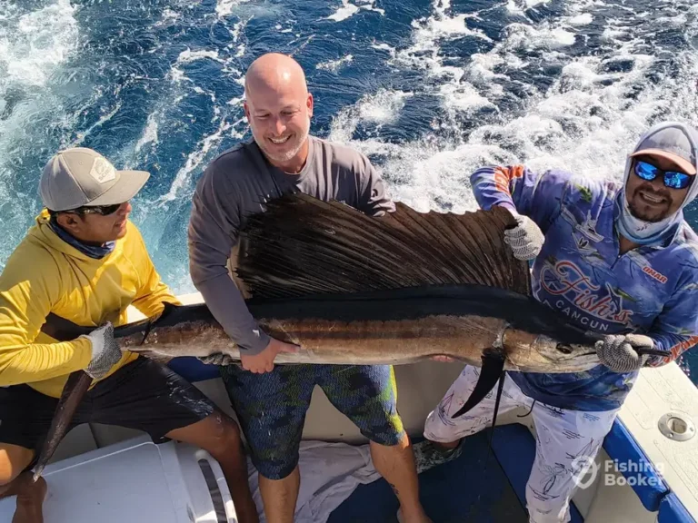 Guests with a sailfish aboard Fish’s
