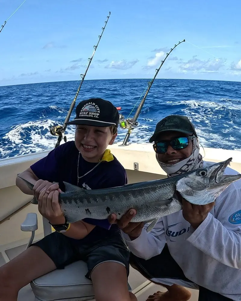 Young angler holding a barracuda
