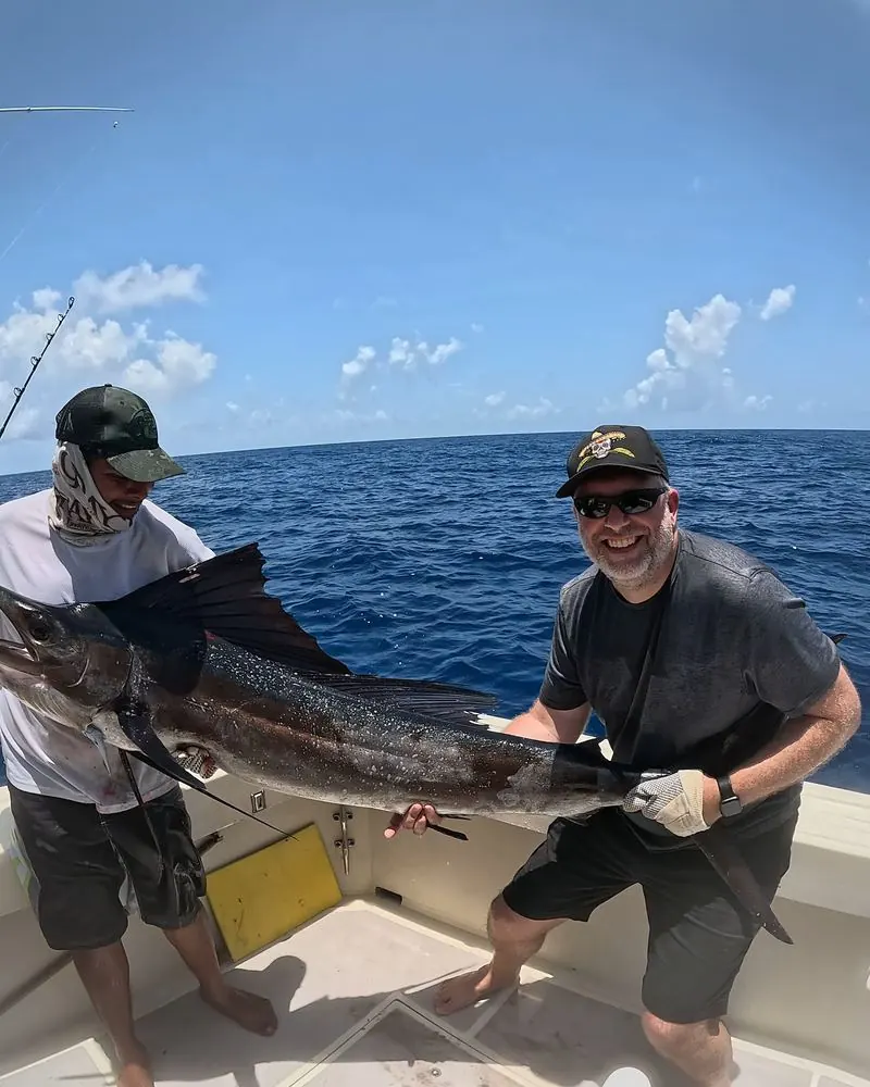 Guest and mate holding a sailfish