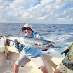 Angler with a large catch aboard a Cancun fishing charter.
