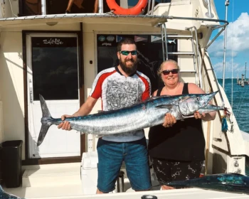 Guests with a wahoo at the dock after a Cape Escape fishing trip in Cancún